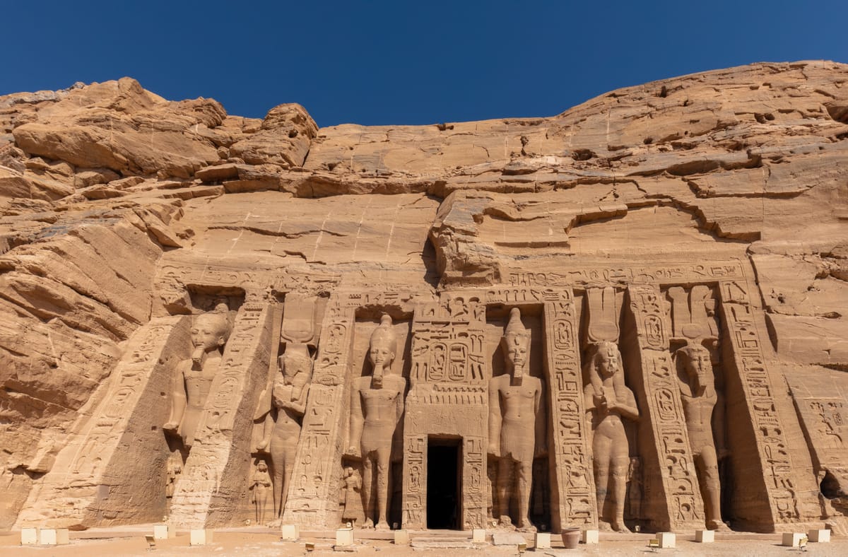 The smaller temple, dedicated to the goddess Hathor and to Queen Nefertari, whose colossal standing figures are carved at the same scale as the king's — a rare honour for an Egyptian queen.