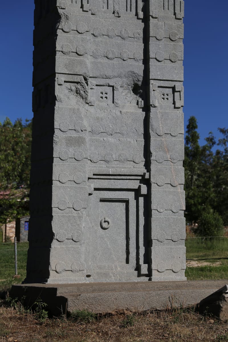 A carved false door at the base of the Obelisk of Axum, complete with a false lock and door handle — one storey of the tower-house imagery worked across the whole monolith.
