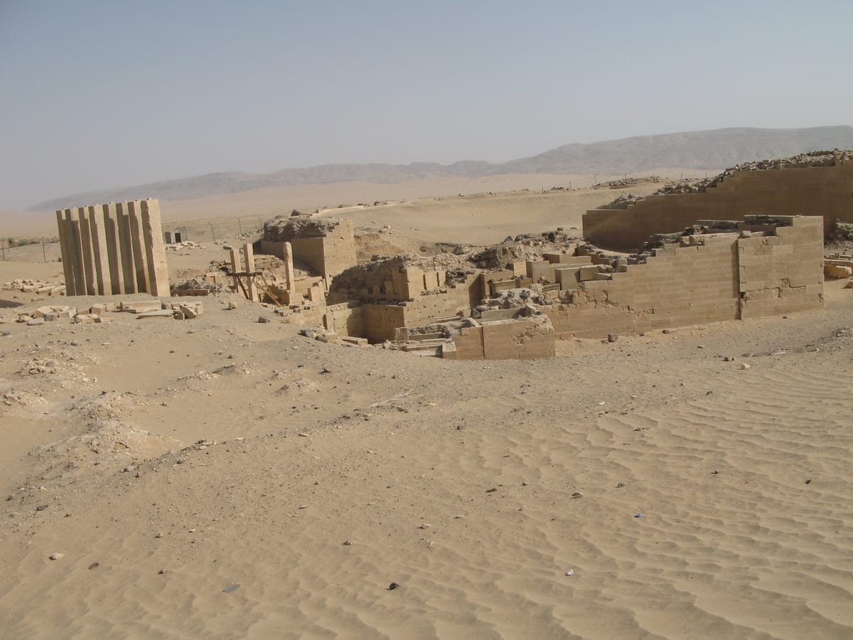 A wider view of the temple's standing pillars amid the surrounding desert and hills near Marib.