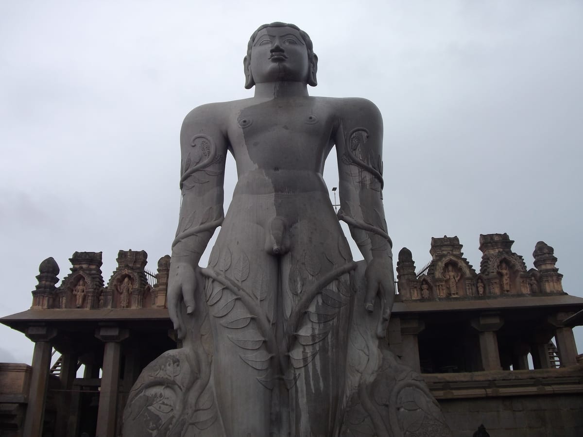 A frontal view of the Gommateshwara statue showing its enclosure and surrounding pillared courtyard.