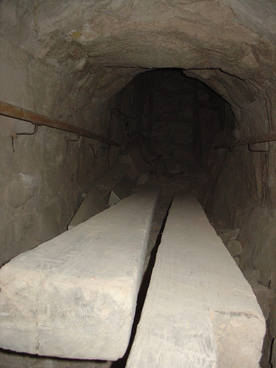 Inside the pyramid: a chamber roofed with a high corbelled vault, built by stepping successive courses of stone inward to carry the enormous weight above without a true arch.