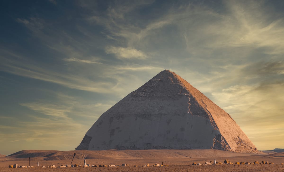 The full profile of the Bent Pyramid. The lower courses climb at roughly 54 degrees; above the bend the angle drops to about 43 degrees, the same angle later used for the neighbouring Red Pyramid.
