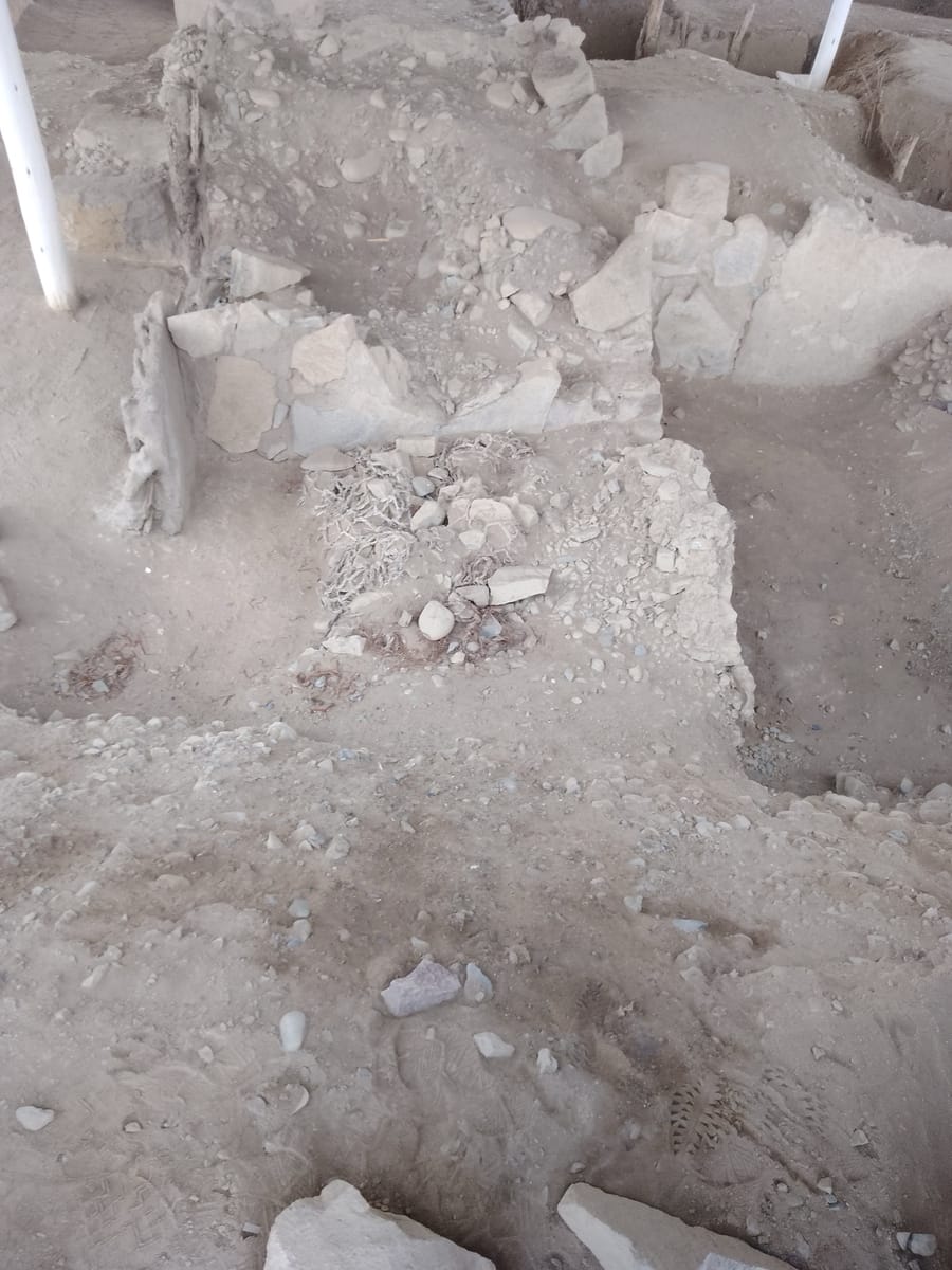 Reconstructed stone architecture at Caral. Excavators found the platforms packed with shicras — loosely woven reed bags filled with stone — that gave the fill its earthquake-resistant behaviour.