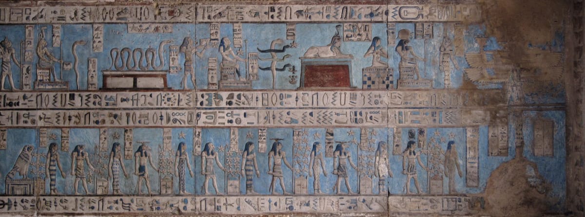 A panel of the painted astronomical ceiling. Cleaning has stripped away centuries of black soot to reveal the original colours: sky goddesses, sun disks, and rows of deities that once seemed almost lost under grime.