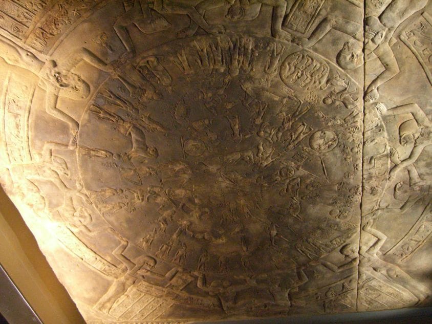 The circular Dendera Zodiac, a sculpted sky-map of constellations and planets added to a ceiling chapel after 51 BCE. The original relief was removed to France in the 1820s and is now in the Louvre; a cast stands in its place at Dendera.