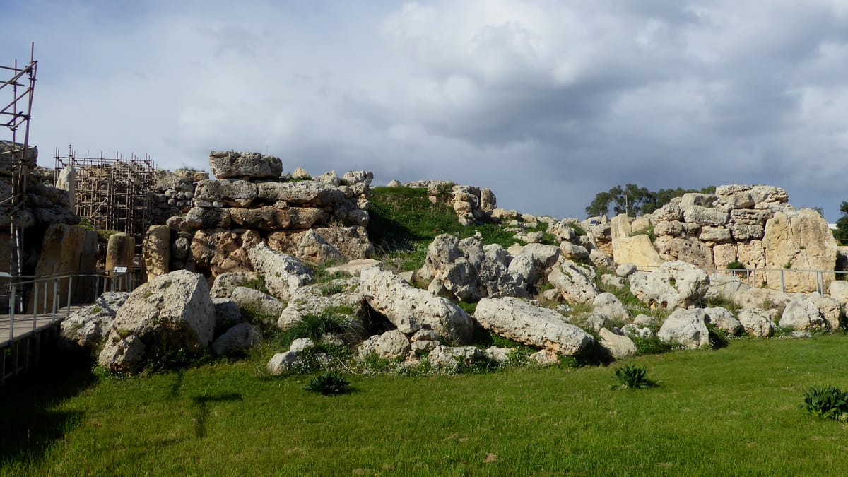 The massive coralline limestone blocks of the collapsed south-eastern boundary wall at Ġgantija, illustrating the scale of the megaliths used.