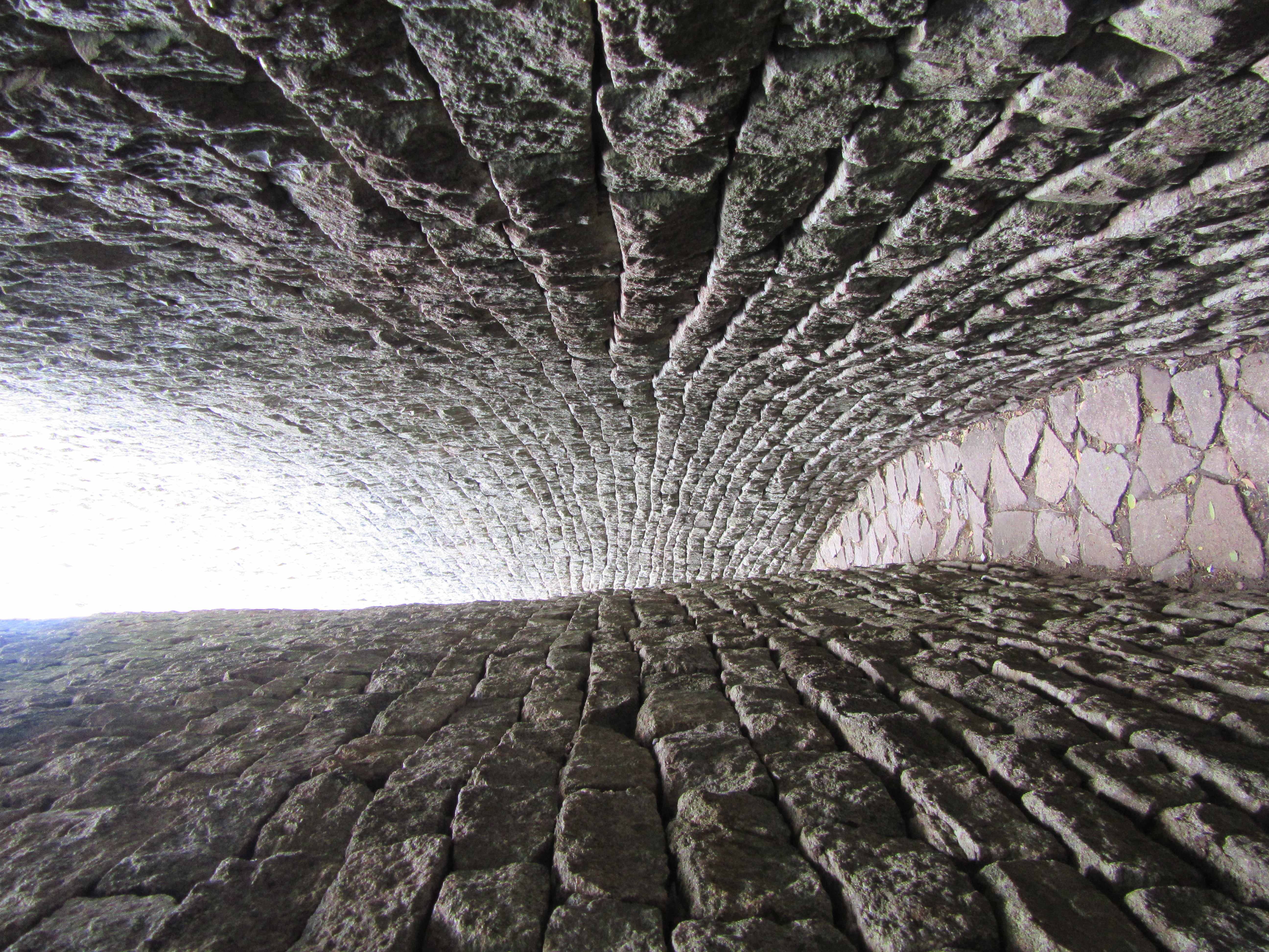 A narrow, curving stone passageway winding around the outside of the Great Enclosure wall.
