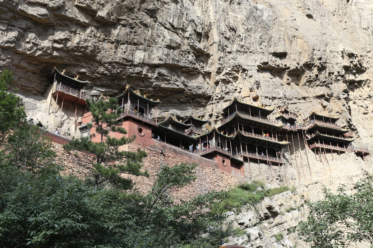 A side view showing how the halls project out from the rock face on slender vertical poles, most of which bear little of the actual weight.