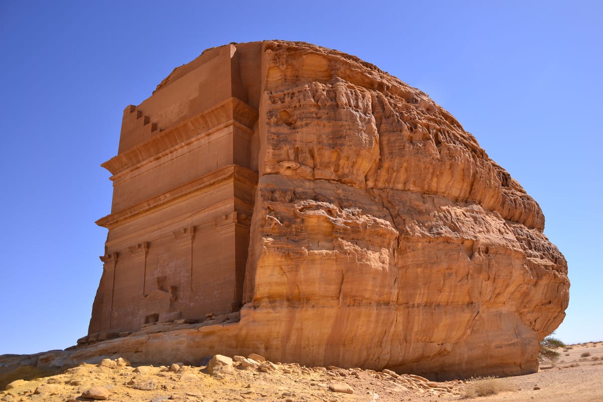 A three-quarter view of Qasr al-Farid, showing how the Nabataeans dressed the carved facade from a natural boulder while the back of the outcrop was left as raw, unworked rock.