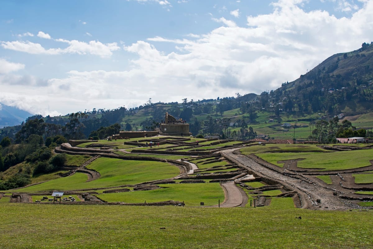 Panorama of the Ingapirca complex from the southeast, showing the terraces, foundations, and the elliptical temple crowning the ridge.