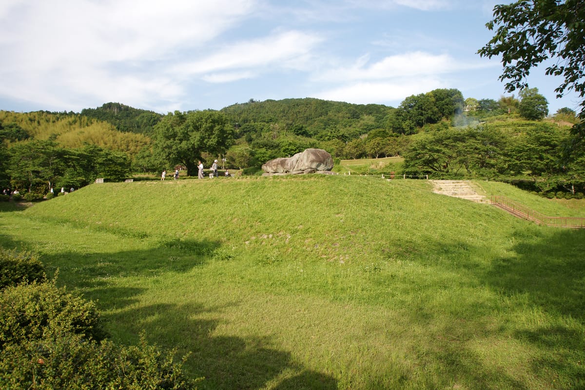 The restored square platform and surrounding moat, with the bare chamber sitting on top where an earthen mound once stood.