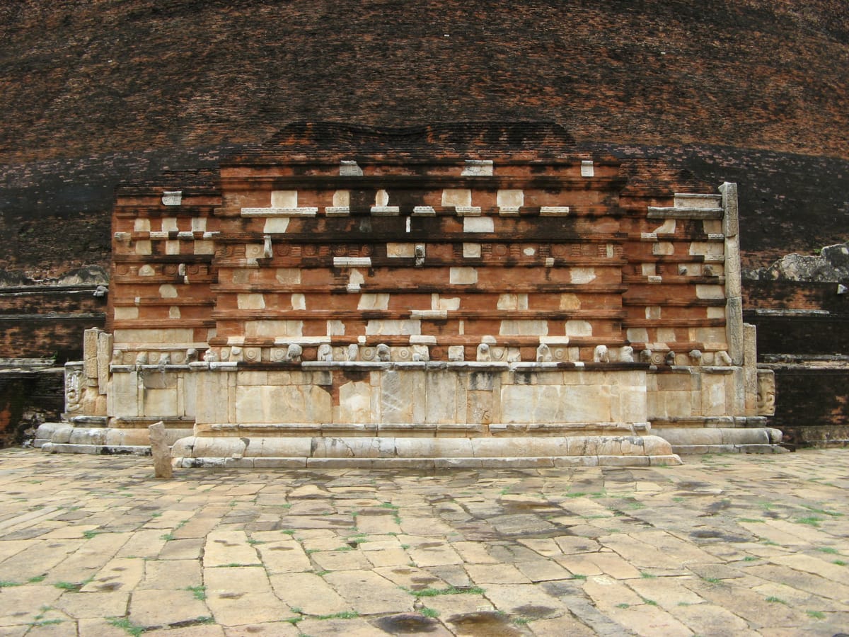 The partially restored south vahalkada, or frontispiece, set against the dark brickwork of the dome. Its base carries a row of carved elephants that symbolically support the structure.