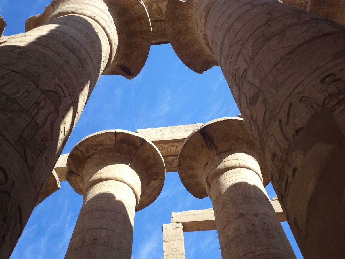 Capitals of the hall's columns, carved and once brightly painted in the form of papyrus plants — closed buds on the shorter outer columns, open flowers on the tall central ones.