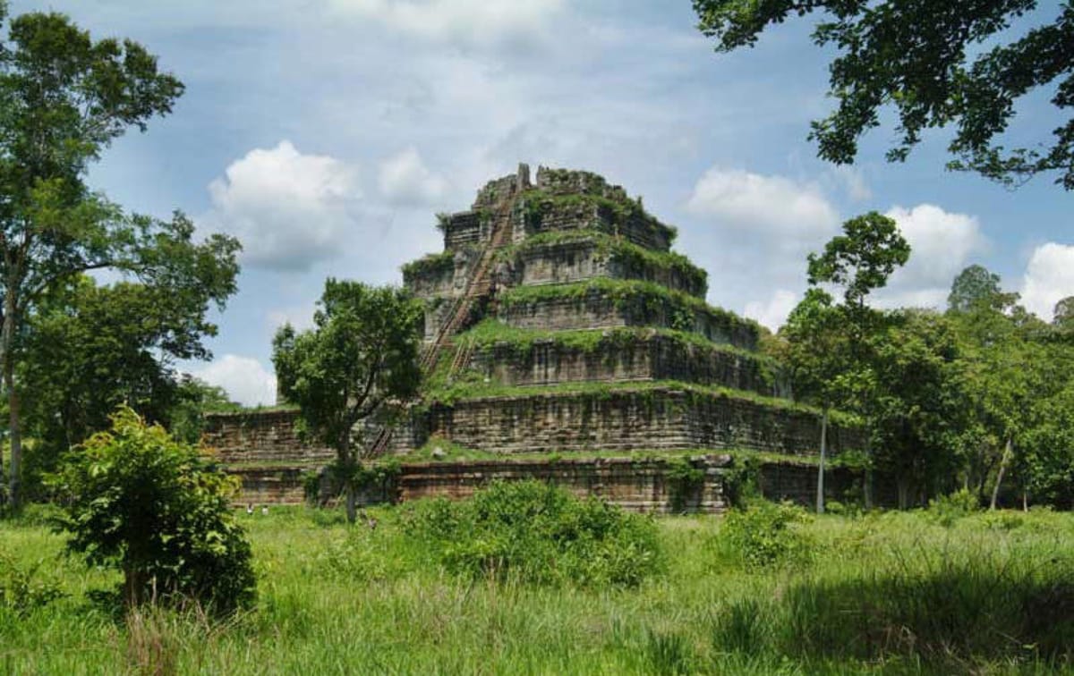 The pyramid framed by wet-season foliage, illustrating how thoroughly the jungle has closed back in around Koh Ker's monuments since the capital was abandoned.