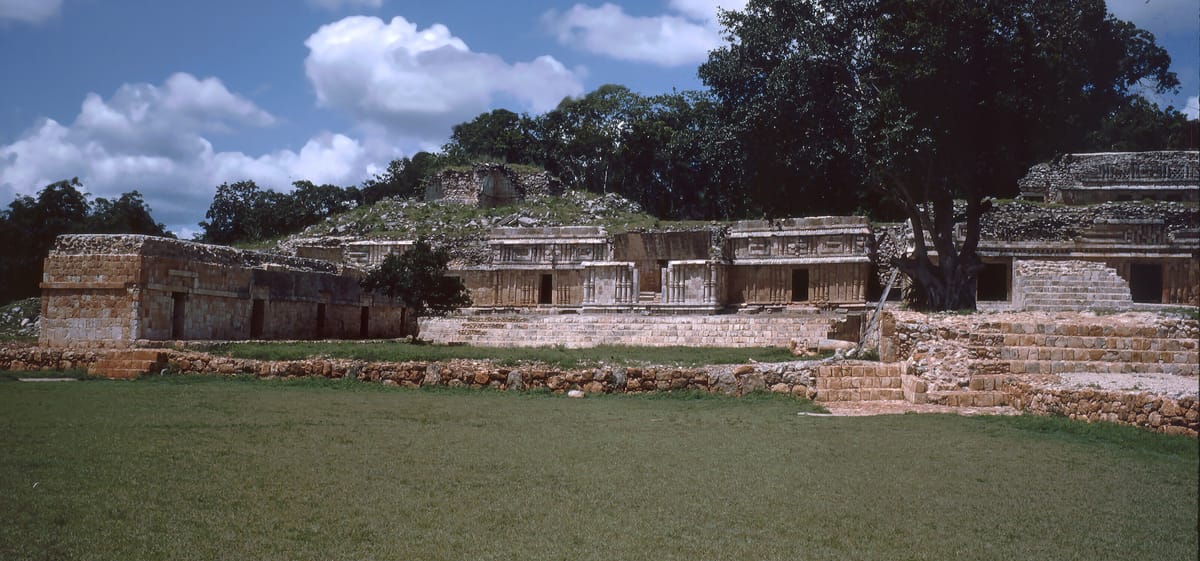 El Palacio at Labná, a two-storey range roughly 120 metres long, carrying colonnettes, mosaic friezes and Chaac masks — including the mask whose nose bears the site's only dated inscription.