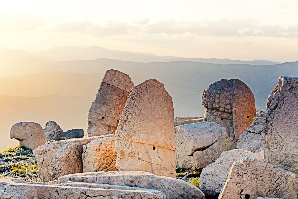 The colossal seated statues of the Commagene cult, originally some 8–9 metres tall, ranged in front of the great tumulus.