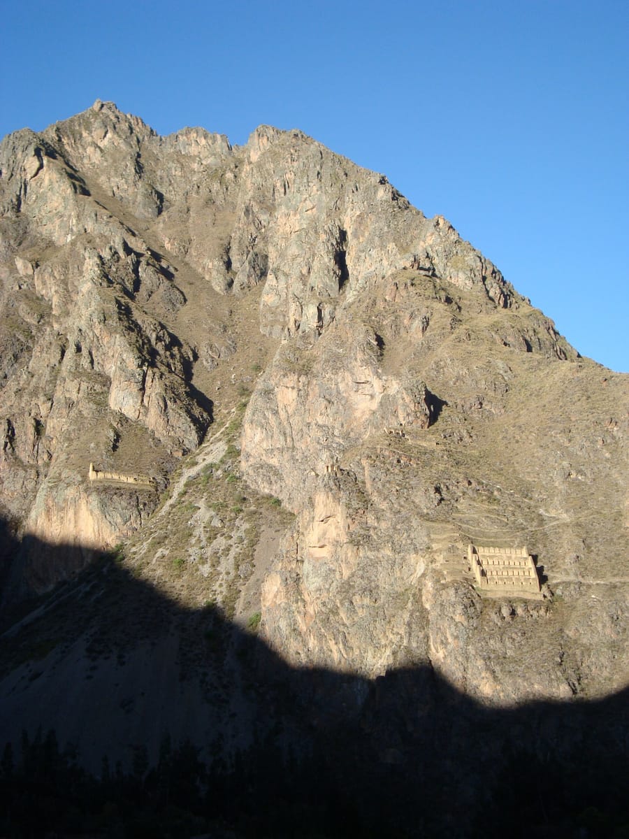 Inca storehouses (qolqas) built high on the hillside above Ollantaytambo, positioned to catch cool, drying winds for grain preservation.