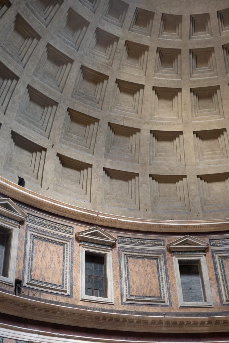 Where the dome meets the drum: the coffered concrete springs directly from the massive cylindrical wall, with the marble-faced attic storey below.