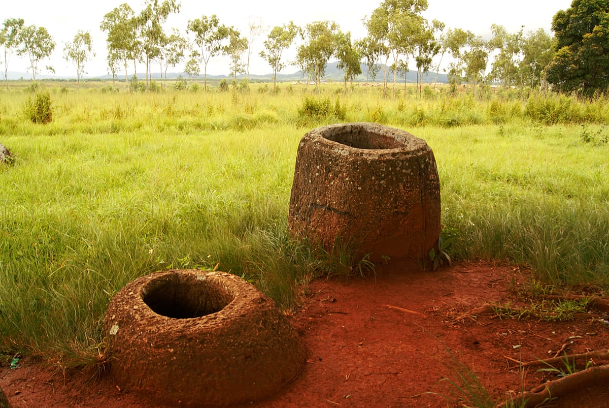 Two jars showing the hollowed interiors and the characteristic form — the body always wider at the base than the rim — carved from single blocks of stone.