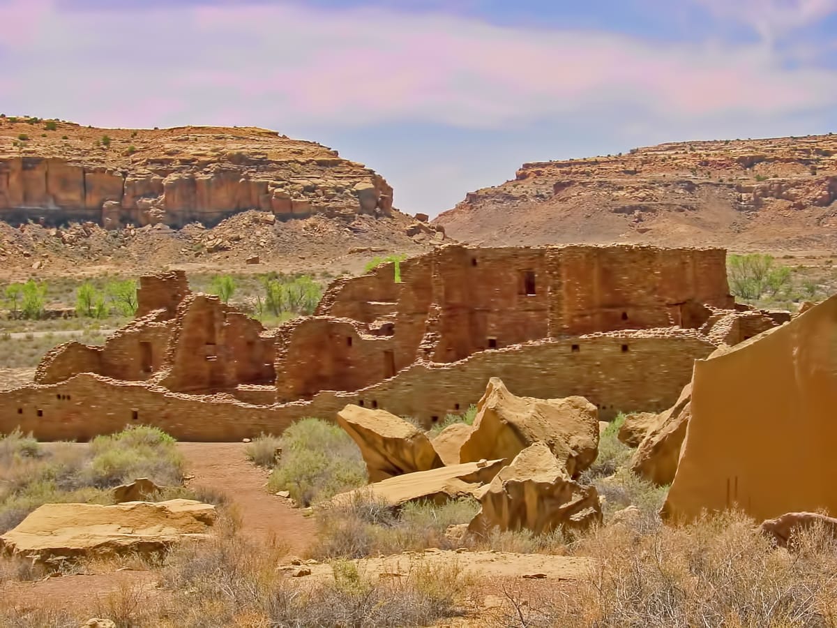 The ruins of Pueblo Bonito's dense room blocks and circular kivas, set beneath the sandstone cliffs of Chaco Canyon.