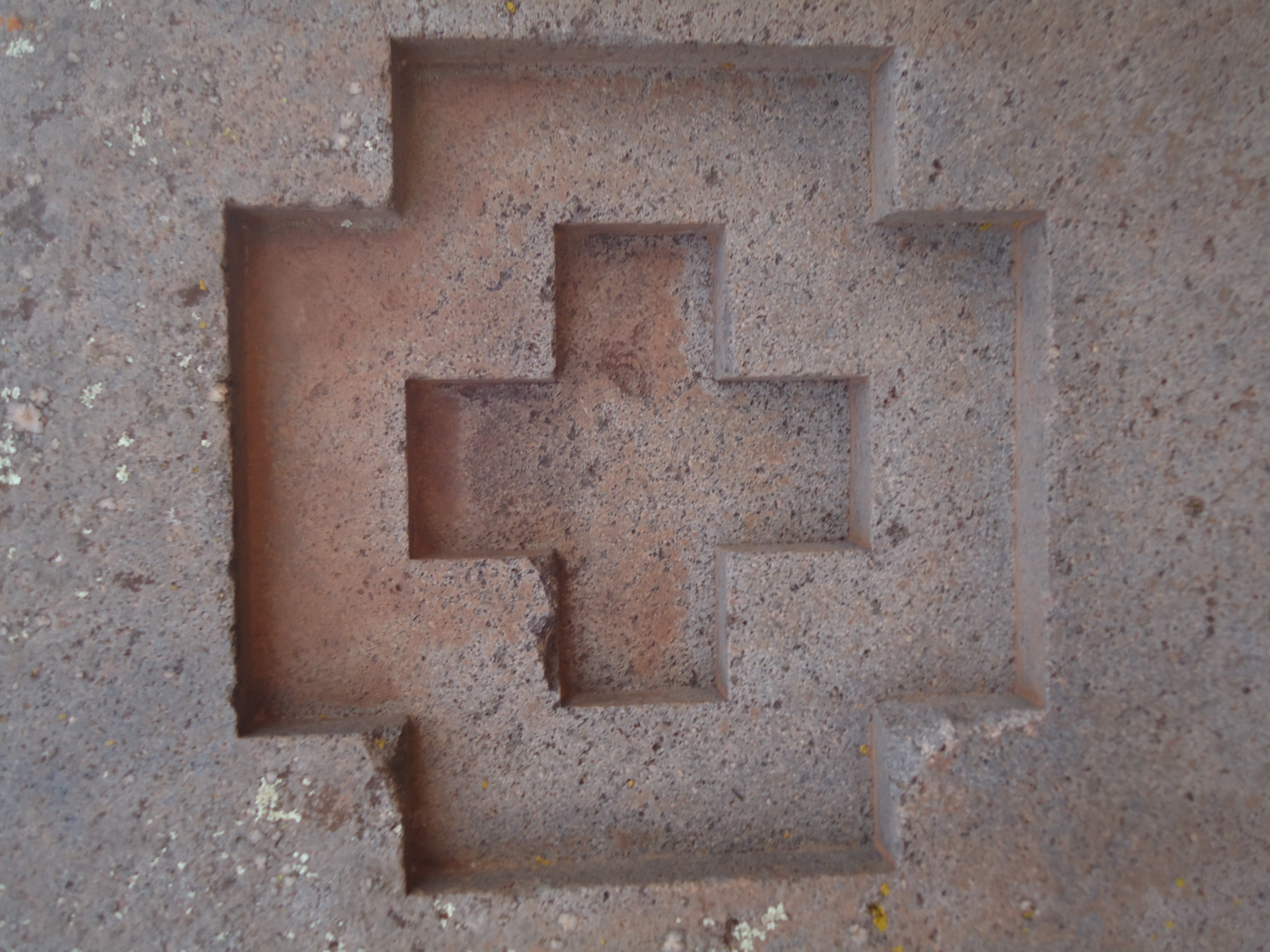 A carved andesite block at Puma Punku, showing the flat faces and crisp edges typical of the site's finest stonework.