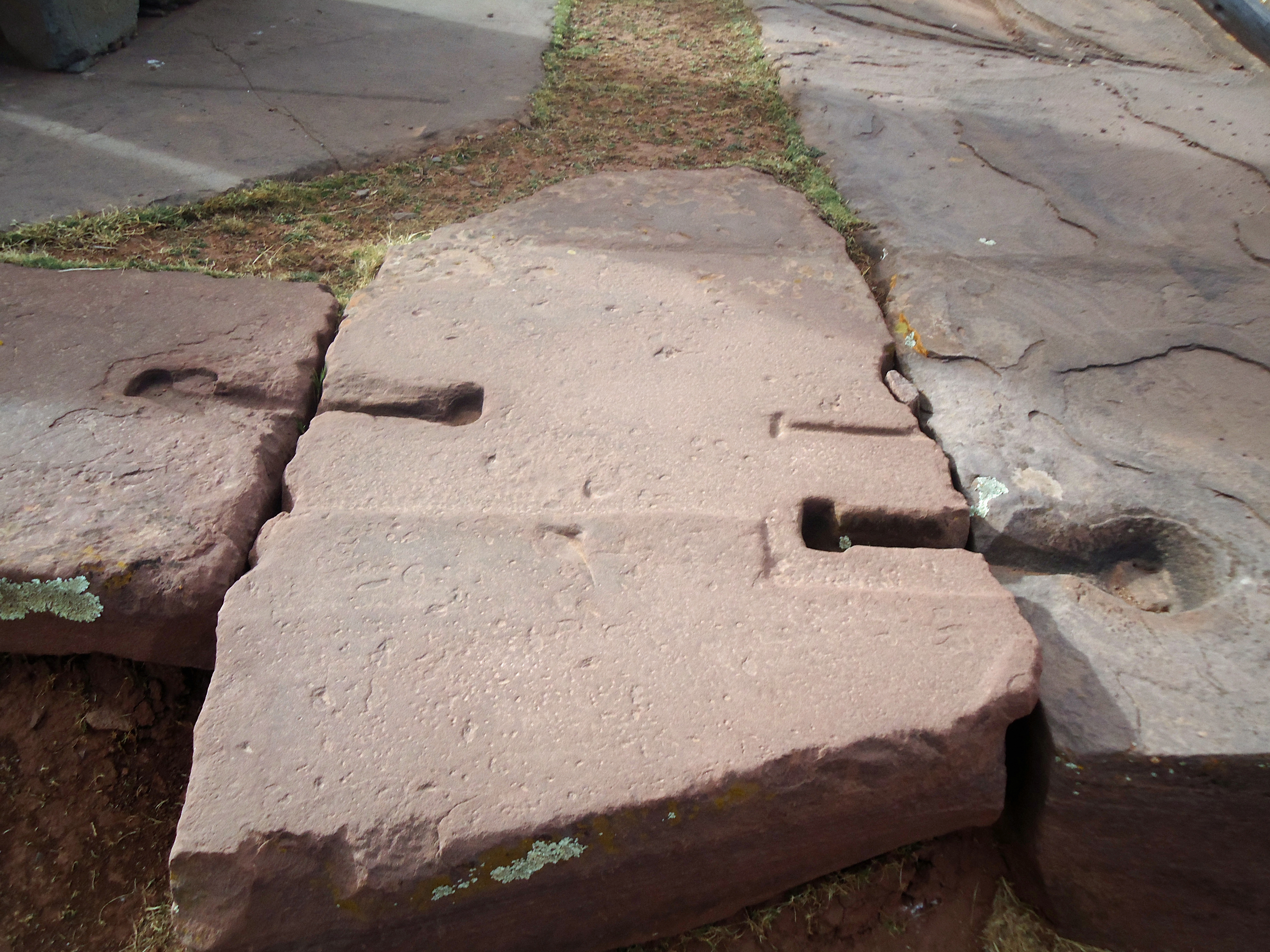 Massive red sandstone foundation plates at Puma Punku, once fastened together with metal cramps.