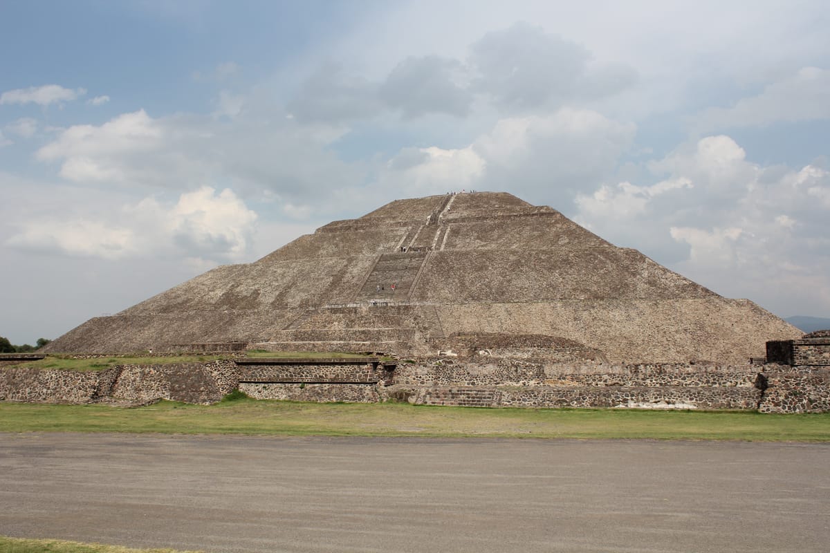 The pyramid's stepped, terraced profile, faced in stone over a core of adobe and rubble fill.