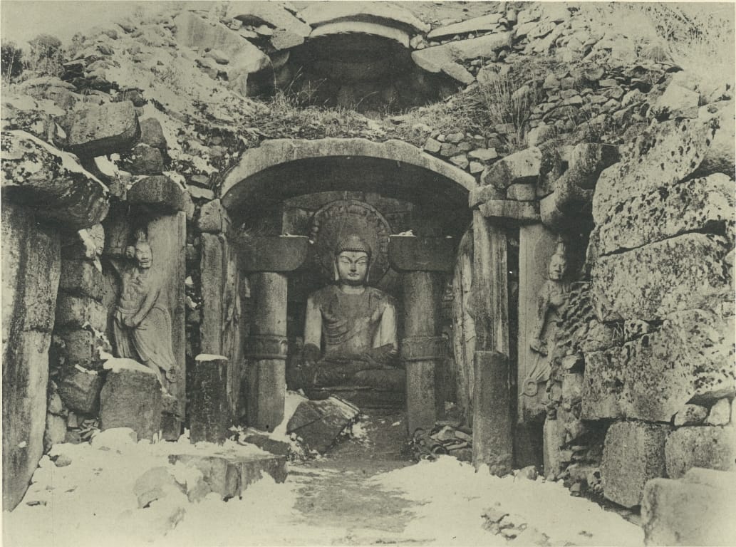 Seokguram before the colonial-era rebuild, photographed sometime prior to 1923: the dome's stone shell stands exposed, its earth covering washed away, with rubble collapsed around the entrance.