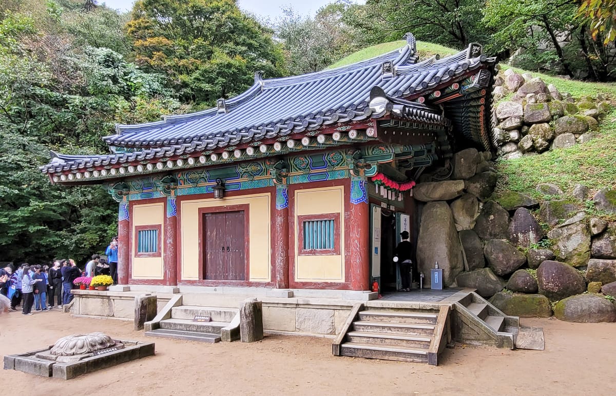 Seokguram today: the wooden hall built across the entrance during the 1960s restoration, with the grass-covered earth mound that conceals the granite dome rising behind it.