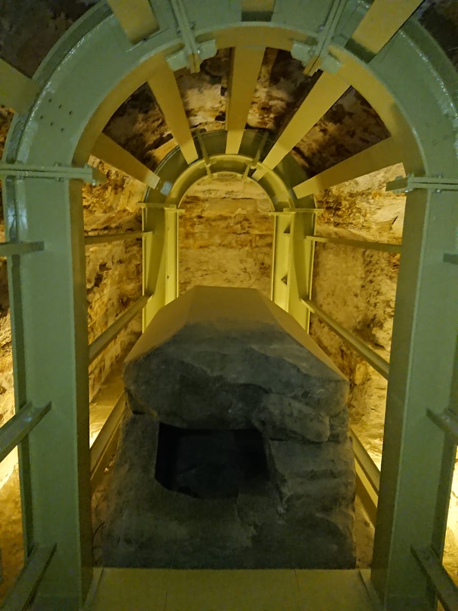 Another of the Apis bull sarcophagi in its side chamber, showing the scale of the hollowed stone box against the surrounding gallery.