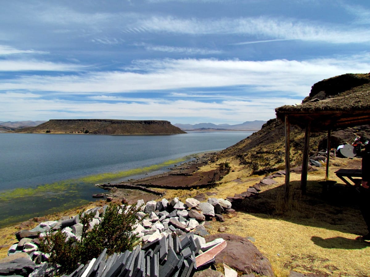 Lake Umayo and its flat-topped island seen from the Sillustani promontory, where the chullpa necropolis stands at roughly 3,900 meters on the Peruvian Altiplano.