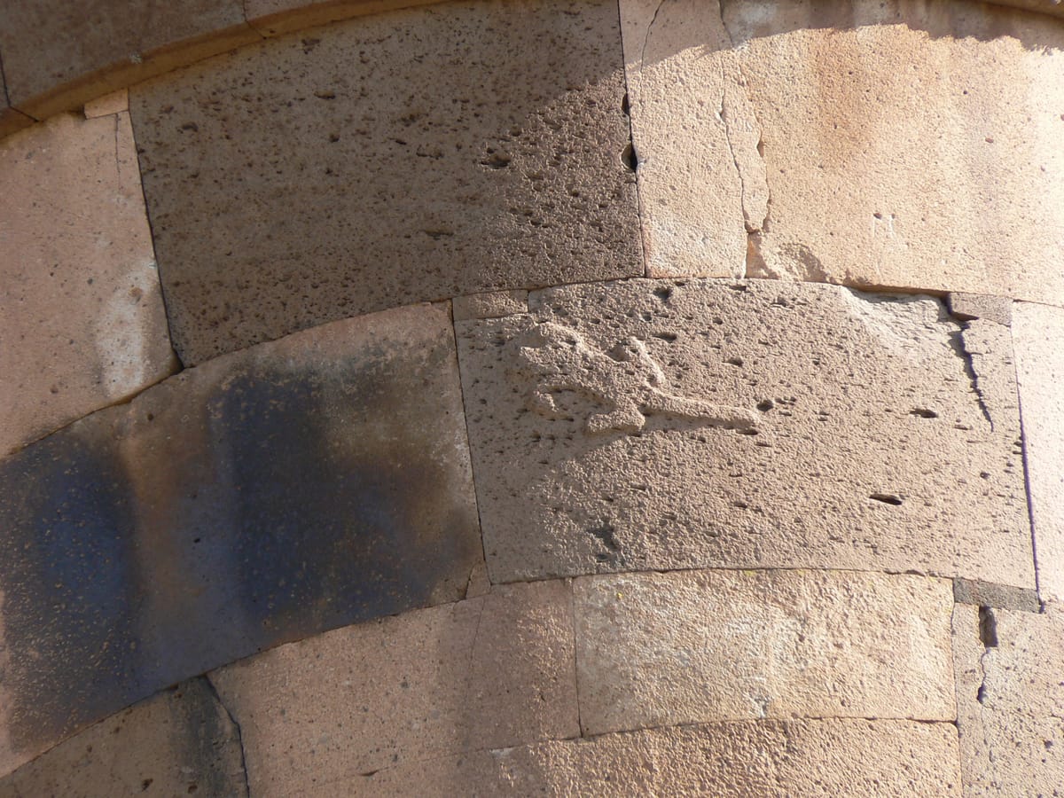 A lizard relief carved into a block of the largest tower — the feature that gives the Lizard Chullpa its name.