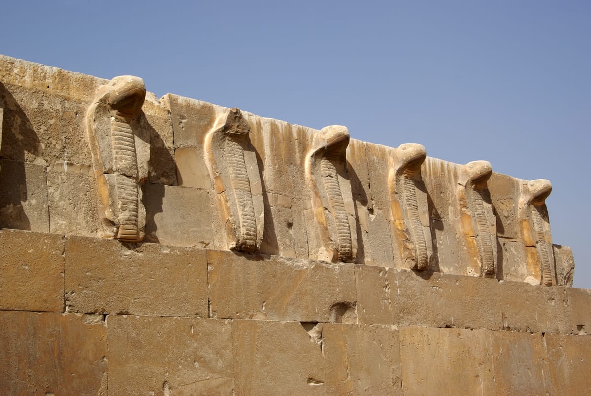 A frieze of rearing cobras (uraei) from the complex — among the earliest monumental stone relief ornament in Egypt, carved in the same limestone that built the pyramid.