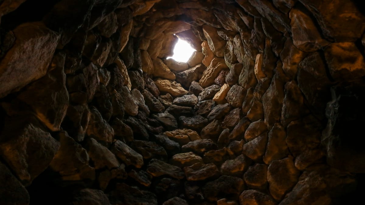 Inside a tholos: the corbel-vaulted chamber of the central tower, its stone courses stepped inward without mortar to close a tall false dome.