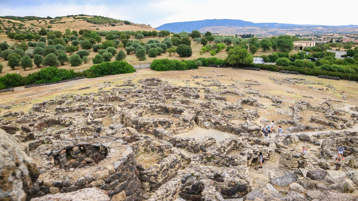 The Nuragic village around the tower — a dense cluster of circular stone huts that grew into a small town of streets, workshops, and meeting rooms.