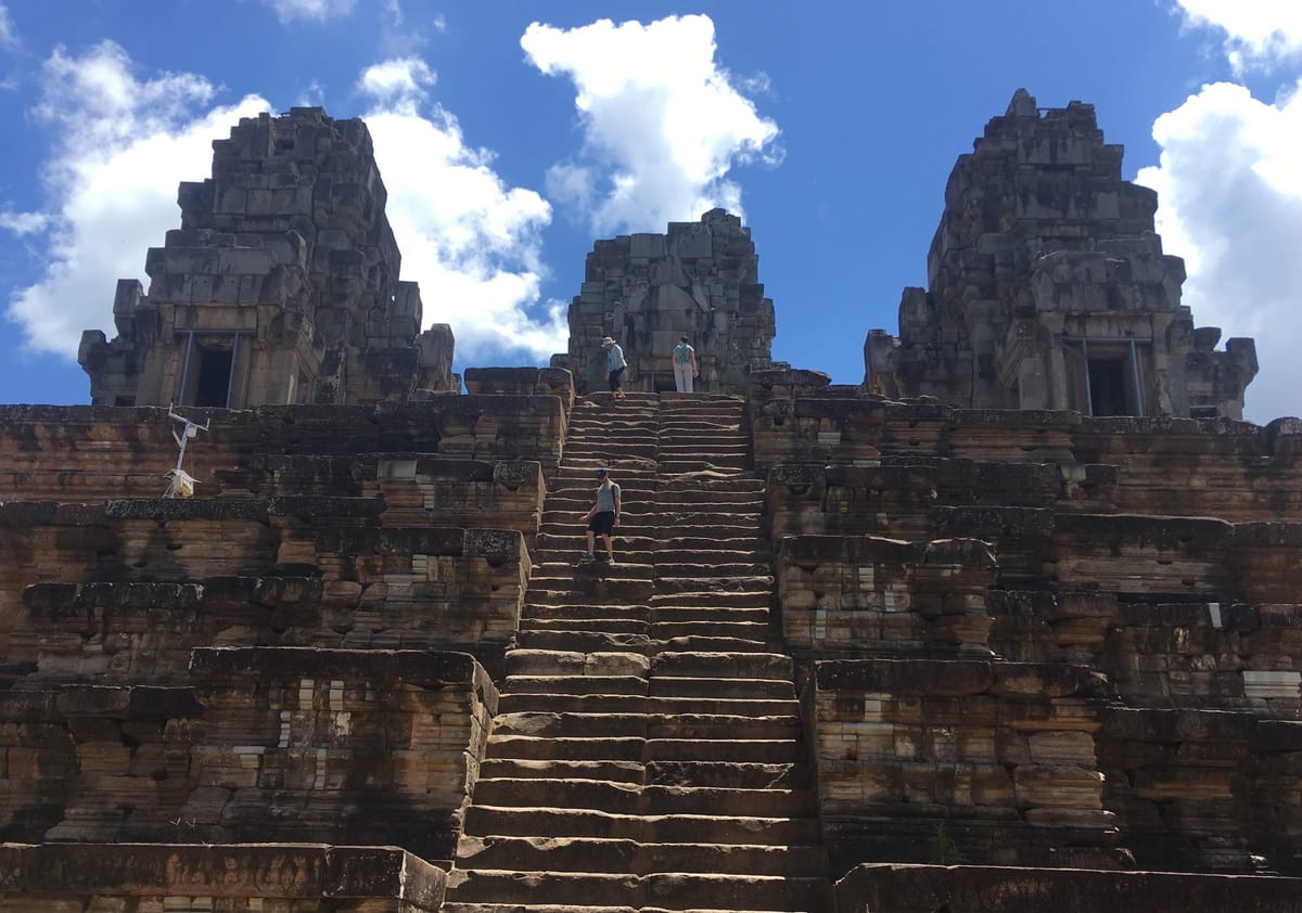The temple's steep, narrow stairways climb the upper three tiers of the pyramid toward the central tower.