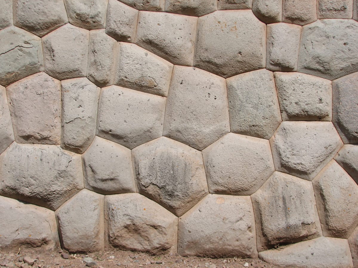 Detail of the dressed andesite stones making up the wall, showing the fine joint-fitting characteristic of Inca 'cellular' masonry.