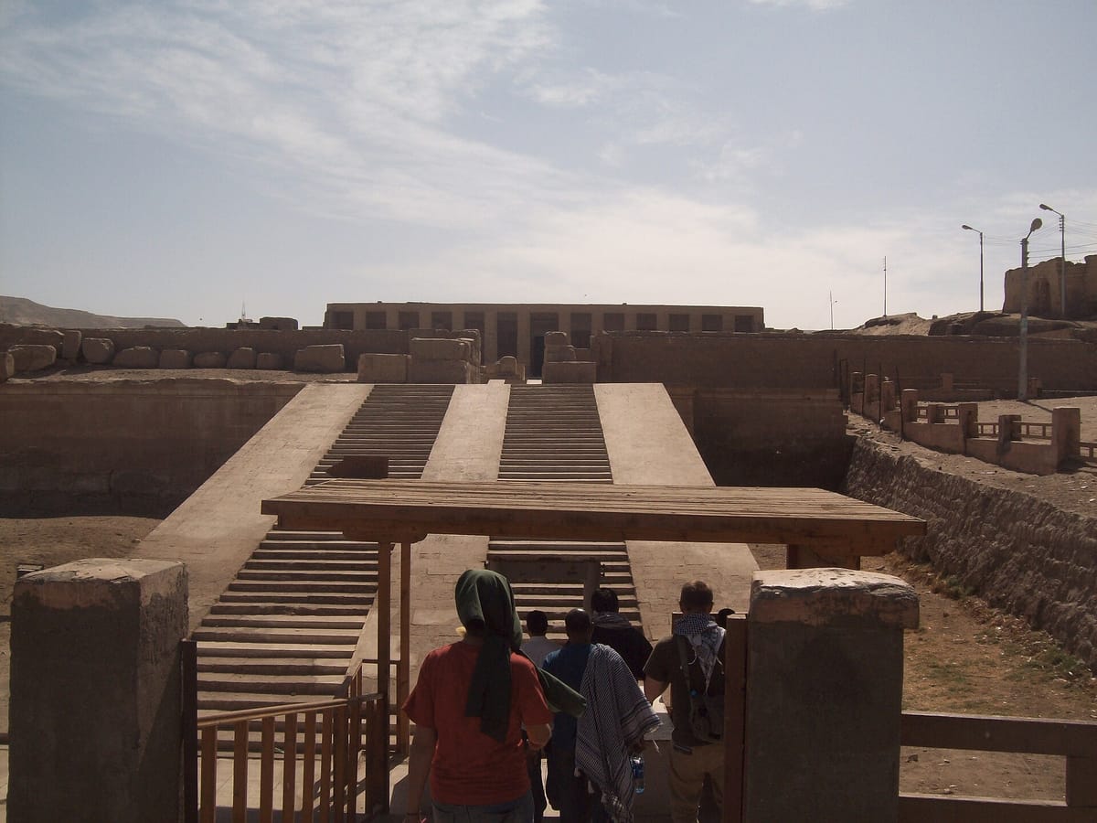 The approach and facade of the Temple of Seti I at Abydos, showing the raised terrace and portico leading into the temple.