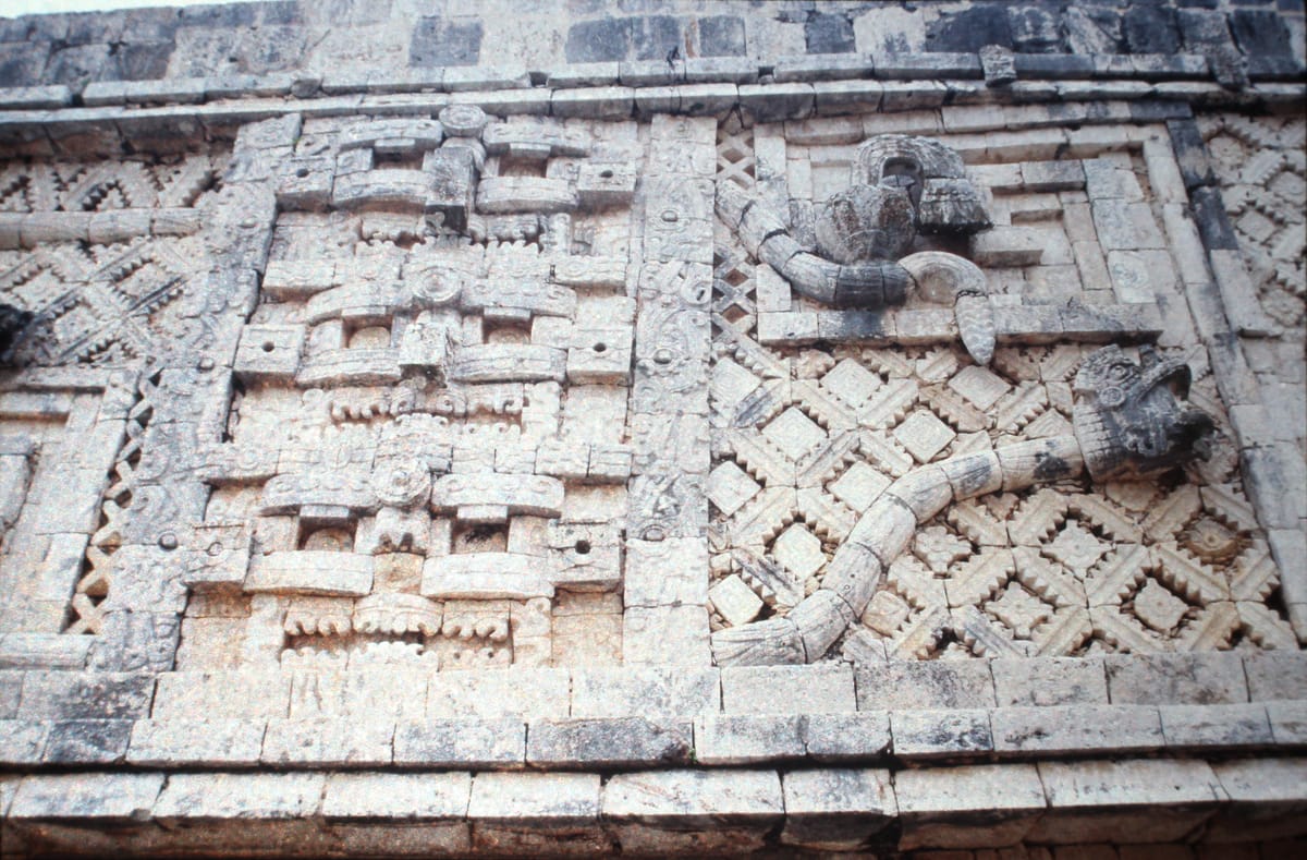 Puuc mosaic work in the Nunnery Quadrangle — latticework and feathered serpents assembled from pre-cut veneer stones rather than carved from a single block.