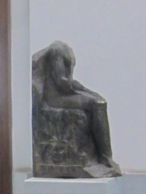 The famous seated statue of Khafre, with the falcon-god Horus enfolding the back of his head, carved from hard anorthosite gneiss. Auguste Mariette found it in 1860 in a pit dug beneath the temple floor; it is now among the masterpieces of Egyptian sculpture.