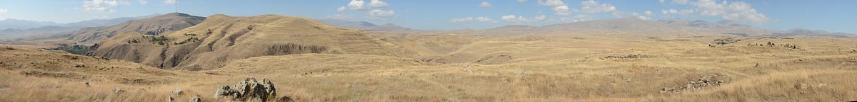 Wide panorama of the stone field, showing the scattered arrangement of megaliths across the plateau.